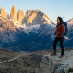 Woman in windproof layers hiking in Torres del Paine in November wind