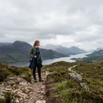 What to wear in Scotland in June: layered outfit with Highland landscape